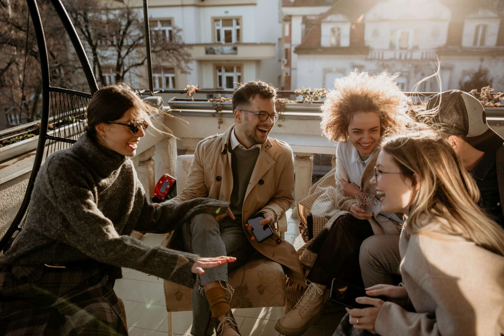 Freunde genießen gemeinsam einen sonnigen Nachmittag auf einem Balkon